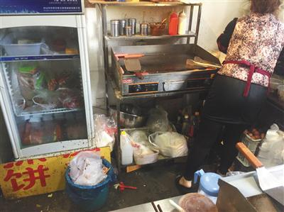 同时入驻了三家外卖平台的“台湾手抓饼”店内，老板娘正在加工食物，店内卫生条件差。后该店被查出无证经营。新京报记者&nbsp;张越摄