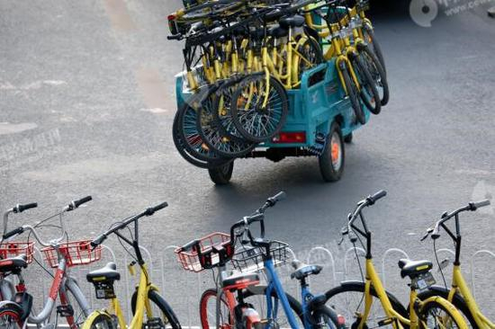 　　公交车站八王坟东附近，ofo的线下运维人员将违规停放的单车清理走。