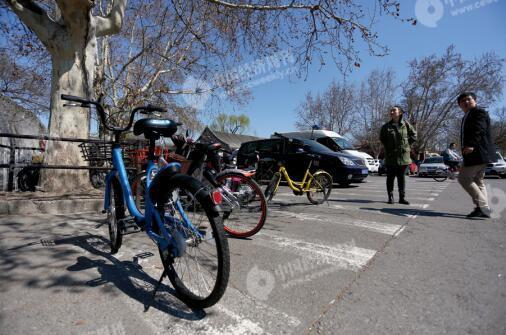 　　北海公园大门附近，违规停靠在斑马线上的共享单车。