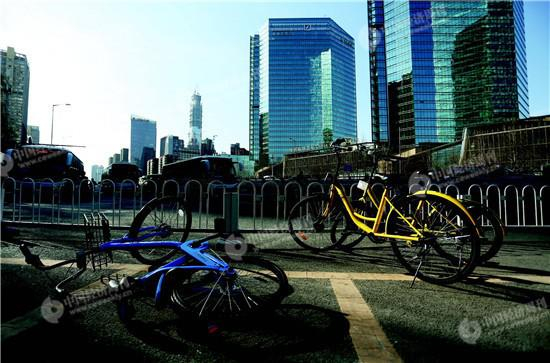 　　北京八王坟东公交车站前，违规停放的共享单车被人推倒。