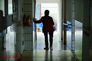 荔湾养和怡老院，一位长者扶着墙走路锻炼身体。