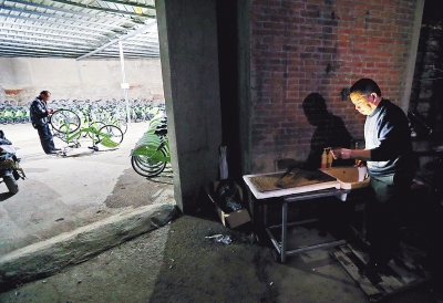 已是深夜，还有很多单车没修理完，犯困的师傅洗把脸接着干。