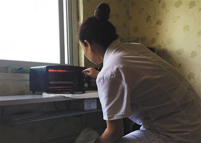 胎盘倒卖者透过烤箱玻璃，观察烤箱中胎盘切片的状态。&nbsp;