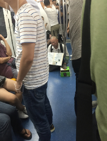 地铁里的乞讨者。管依萌摄