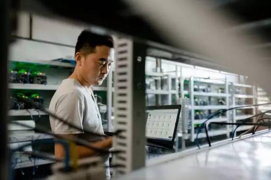 比特大陆的一名维护人员在监控比特币矿机