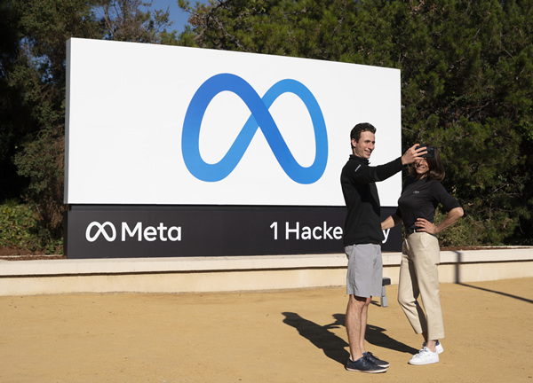 今年10月，美国社交媒体巨头脸书宣布更名为“元”（Meta），聚焦元宇宙。图为在美国旧金山湾区，人们在“元”标志牌前留影。（图片来源：新华社）