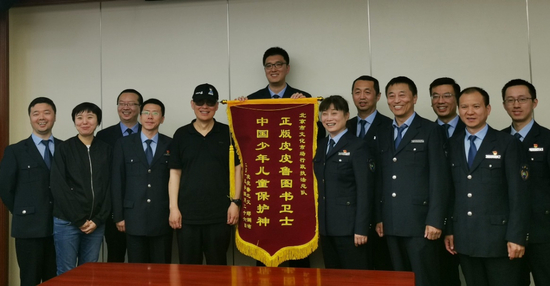  郑渊洁为北京文化市场执法总队成功破获盗版皮皮鲁图书案送锦旗。冯艳/摄