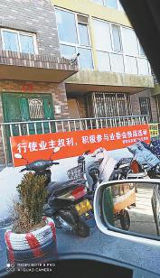 西引力小区内，居委会张挂横幅，动员业主重新选举业委会。