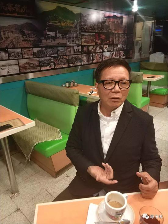 昔日慈云山十三太保之首、1987年香港十大杰出青年陈慎芝在九龙一家他最喜欢的咖啡厅谈及慈云山往事，墙上背景为九龙城寨老照片。 &nbsp;《等深线》记者 &nbsp;周远征 摄影