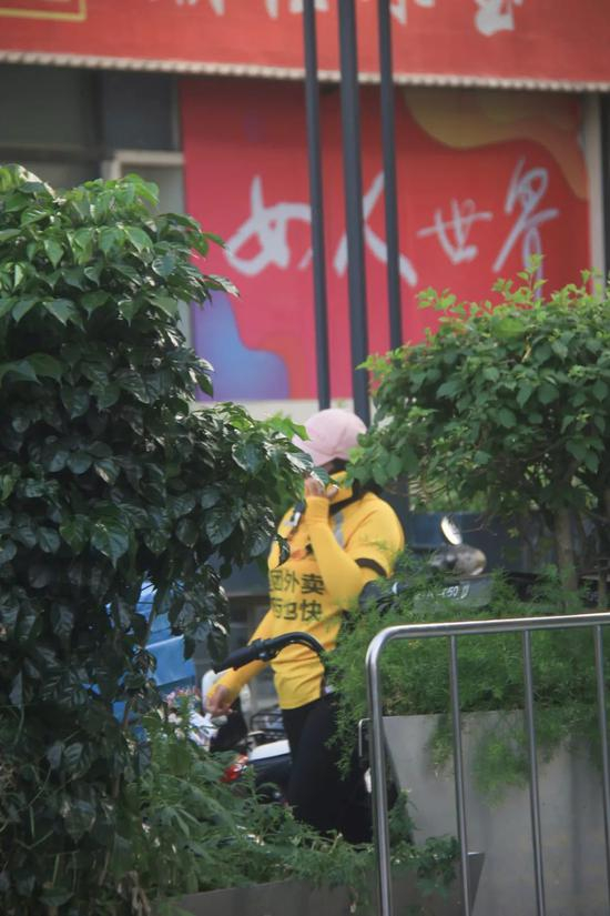  图 |&nbsp;“女人世界”广告牌与正在跟顾客联系的女骑手