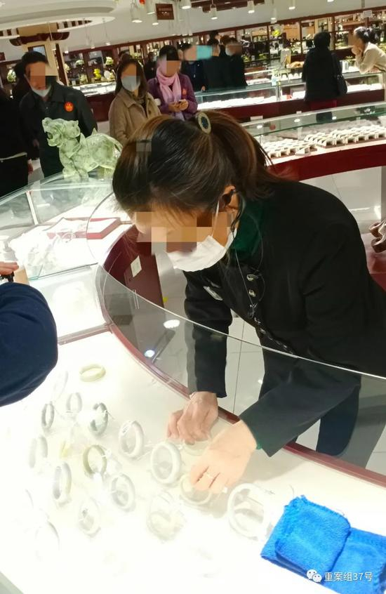 ▲玉器店店员在向游客推销玉镯。新京报记者 吴采倩 摄