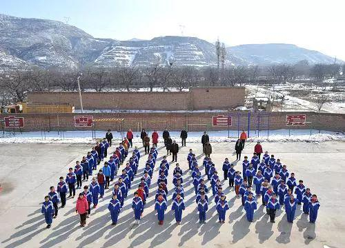  图为2014年2月19日山西省太谷县井西小学的师生合影。井西小学是一所农村小学，辐射了周边两个村庄。图源：新华社|燕雁