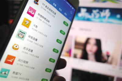 　　用户使用手机安装的直播软件与网页直播画面。针对未成年人单独网络直播，2019年初湖北出台相关规范作出要求。资料图片/IC photo