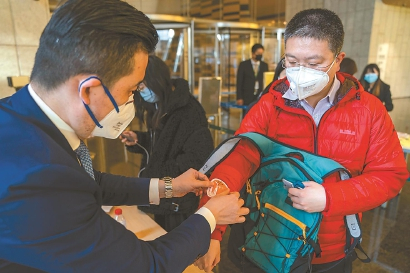 工作人员给白领贴上“当日贴”，这样才能在上海中心大厦内通行。本报记者 孟雨涵 摄