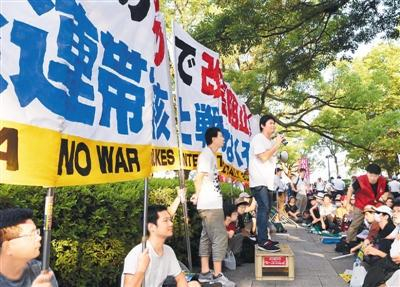 8月6日，日本广岛市在和平纪念公园举行原子弹轰炸73周年纪念活动。与此同时，数百名民众聚集在活动现场附近，抗议日本首相安倍晋三参加纪念仪式，并表示坚决阻止安倍内阁的修宪企图。图为日本广岛原子弹爆炸遗址旁，市民举行抗议活动。 新华社记者马平摄