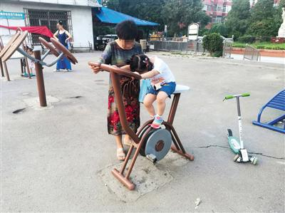 朝阳区周井大院社区，玩耍的孩子够不到直立健身车的踏板。新京报记者 张璐 摄