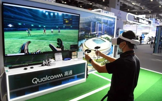 ▲2022年9月1日，国家会议中心一期展馆，观众在高通展台5G设备支持下的“工体元宇宙”体验踢足球。新京报记者 王颖 摄