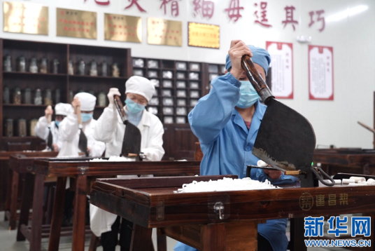 工人使用建刀切制白芍饮片。新华网吴国龙图