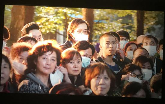 程勇被判刑后，无数病友摘下口罩向其致敬并目送。摄影：李秀芝