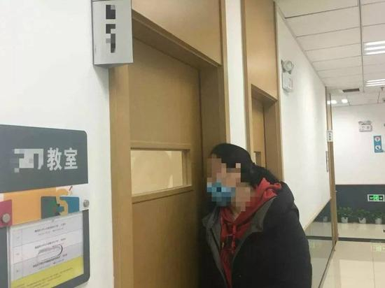 　一位家长在教室门口观察孩子的学习情况