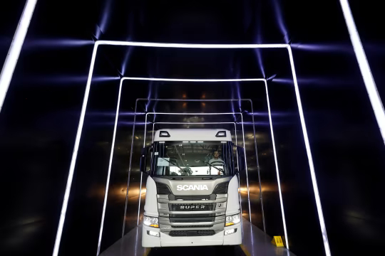 一名工人在生产线末端驾驶一辆全新白色斯堪尼亚卡车。