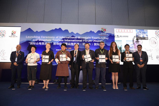 来自8个国家的游客代表获赠中国集邮总公司专门发行的《国际山地旅游日纪念首日封》