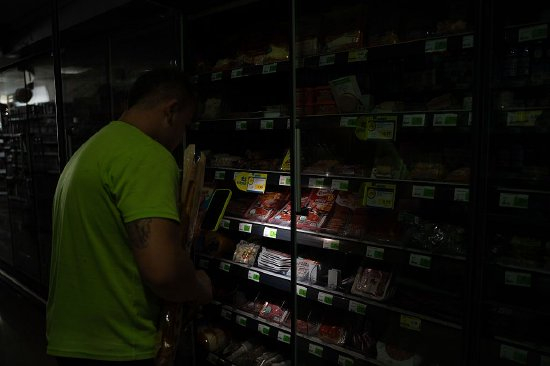 西班牙Tremp的一个超市里，消费者用手机电筒购物