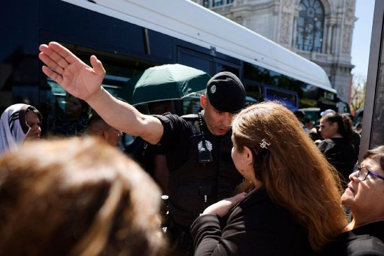 4月28日，马德里公交车站一名警察引导乘客。