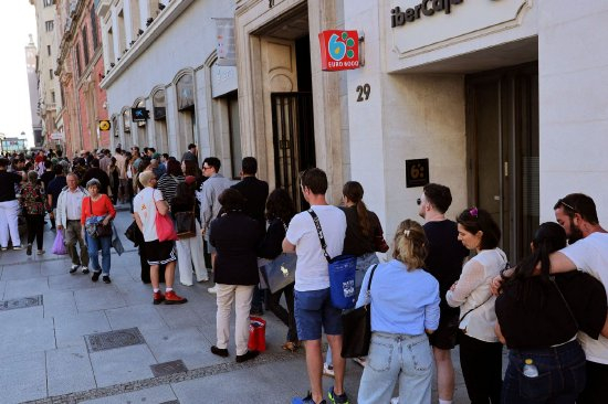 马德里，人们在排队使用ATM机。
