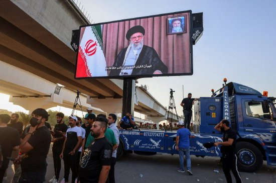 6月16日，巴格达的一次抗议活动中，支持者观看伊朗最高领袖哈梅内伊的演讲。