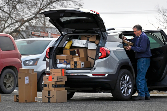 2023 年，明尼苏达州伯米吉市，一名男子正在搬运包裹，准备配送。