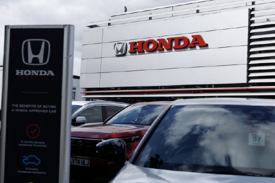 一家本田门店外景，建筑上醒目展示本田标志，前方停放多辆汽车。因北美电动汽车市场放缓，本田正取消部分车型的推出与研发。