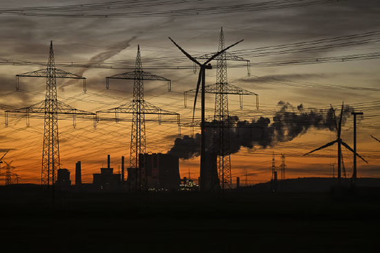 德国西部，莱茵集团运营电站冷却塔附近的风力发电机与输电线路。