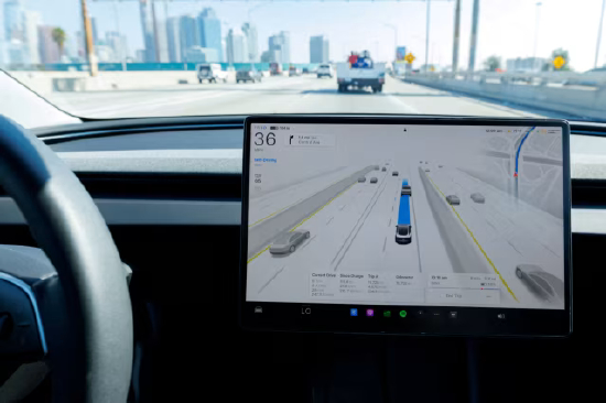 一辆特斯拉 Model 3 在洛杉矶高速公路上开启自动驾驶行驶，车内全自动驾驶软件界面可显示周边路况与导航信息；该车辆为 2025 款特斯拉 Model 3。
