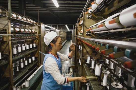 浙江永新集团的女工在加工纺线（蔡小川 摄）
