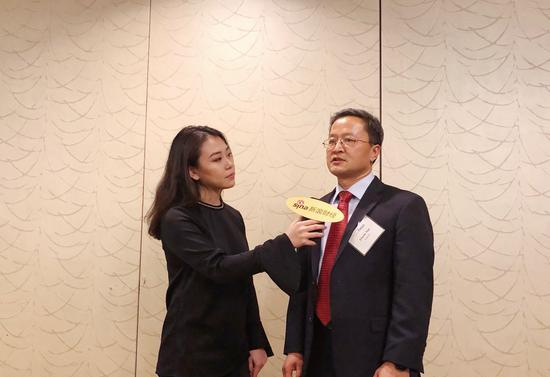 图为GuruFocus的CEO田测产（右）