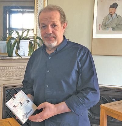 让·霍沃勒卡展示其父亲编写的中医书籍。 　　本报记者 于 洋摄