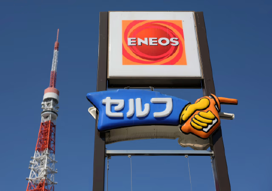 加油站标识上展示着引能仕（Eneos）公司 logo，背景可见东京塔。 雪佛龙表示，此次资产组合调整是 “为顺应不断变化的市场格局”。