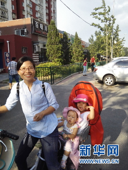夏日街头，小刘带着两个孩子去给客户送保单。