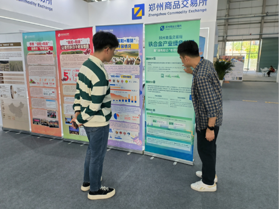 （图注：郑商所展台工作人员介绍铁合金产业绿色发展项目）