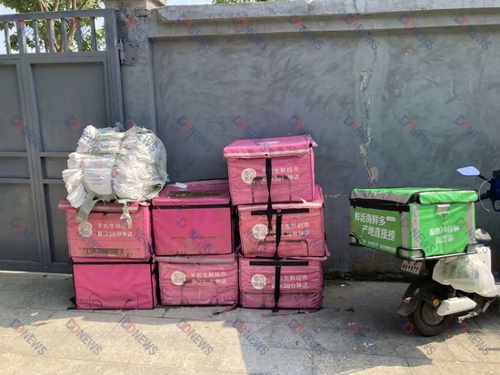 图注：前置仓门口每日优鲜和美团买菜的箱子