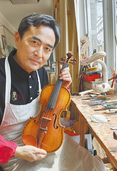 制琴师吕官宝展示雕花琴。 　　吕逸菲摄（影像中国）