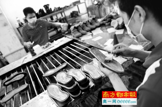 东莞厚街一小制鞋工厂，设备简单，工人手工黏合鞋底。