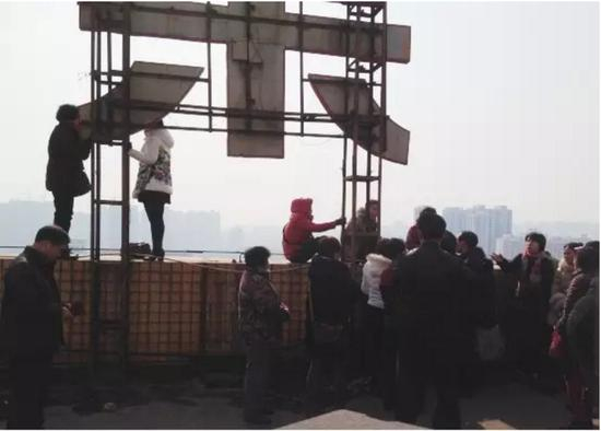 （图片说明：众多投资者在洛阳市芳达大厦17楼平台上欲以跳楼的方式维权）