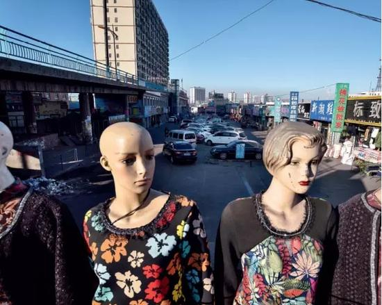 　　外来人口的聚集，让这个早年荒凉的小城人口规模膨胀到约10万人，而今，这条曾拥堵的道路两旁，随处可见店铺在转让