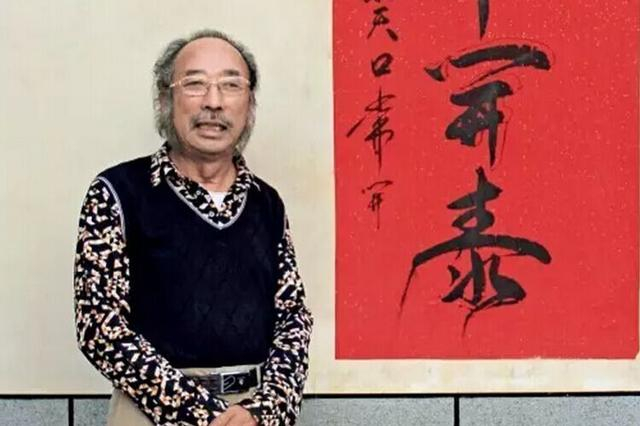 陈德良与他写的一幅字合影，这幅字写着“三羊开泰”