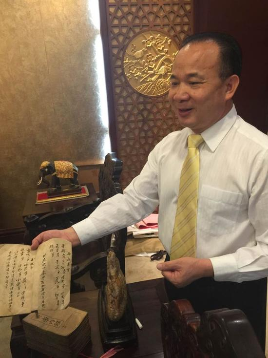 图为陈启源为记者介绍他们家族的中医方面的藏书