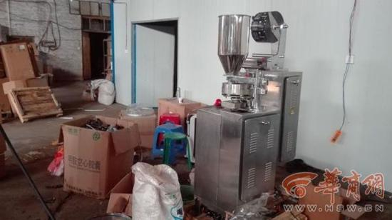 黑窝点内，生产的减肥胶囊随意摆放，包装箱堆满整个厂房，生产伪劣产品的机器摆放在墙角。