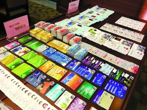 广东警方收缴的大量银行卡和身份证。资料图