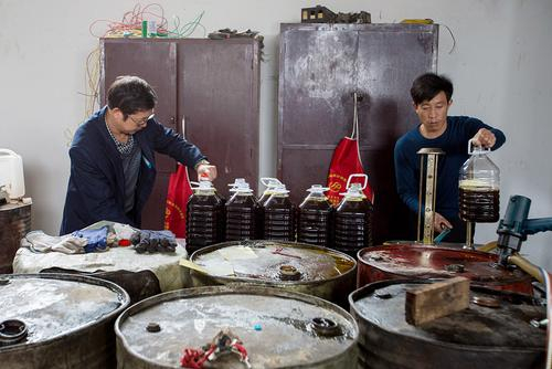 老邬在他的初中同学开的油坊里，灌装压榨好的菜籽油。